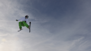 freestyle skiier in the sky with clouds behind them